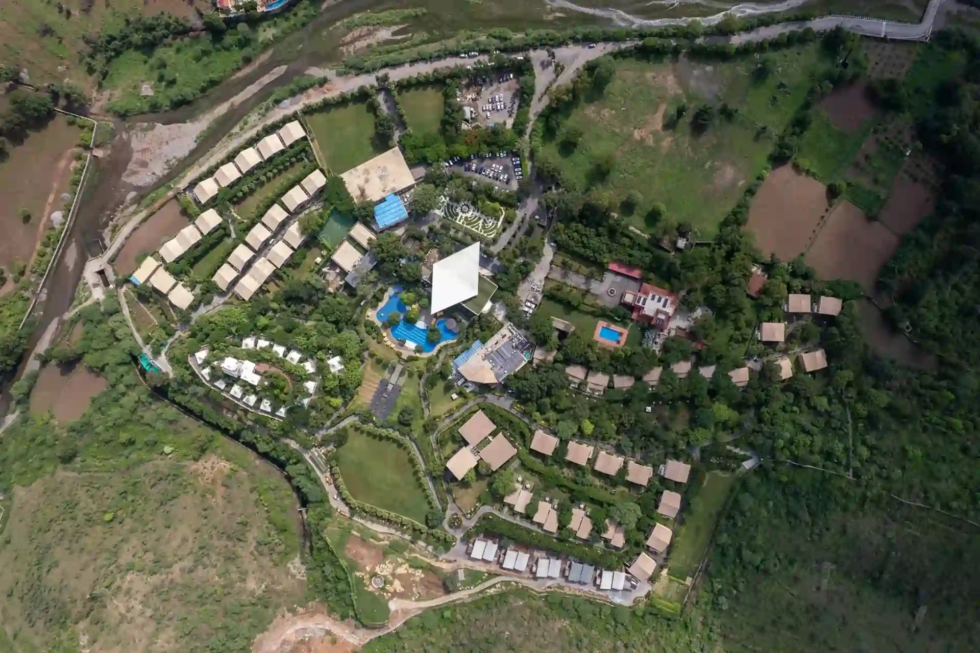 Aerial view of Elevate Samava farmhouses in Naugaon, Alwar with Aravalli hills and greenery